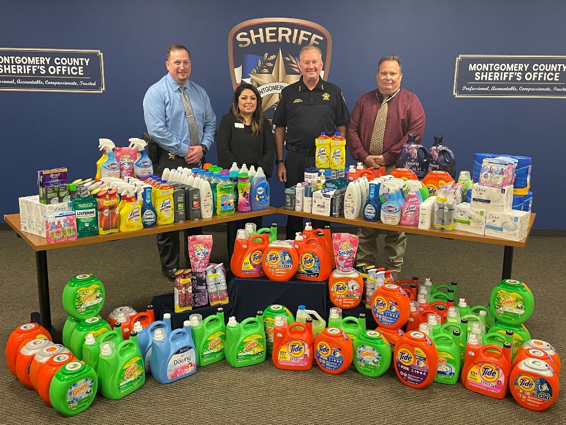 Group photo with Sheriff Henderson and all of the seized items donated to the women's center. 